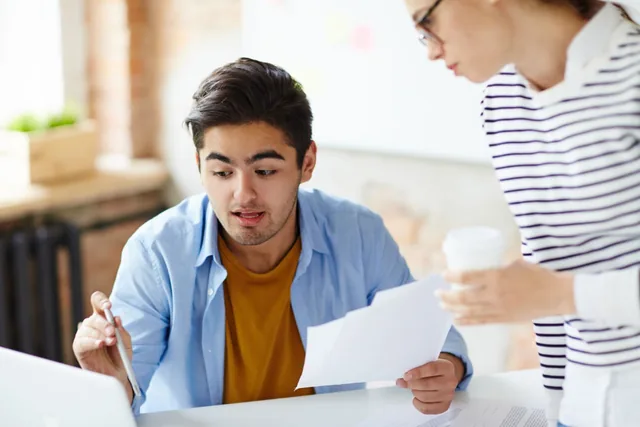 Two colleagues reviewing a financial document together