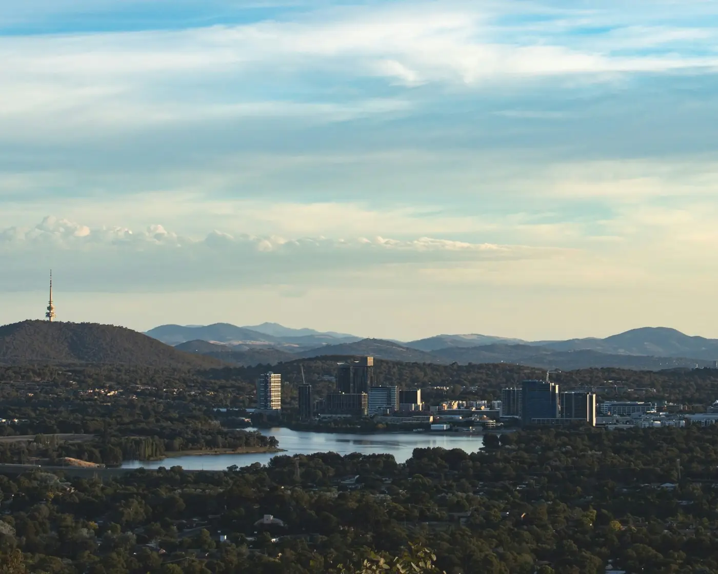 Canberra in late afternoon light, with Black Mountain Tower and the Brindabella Ranges behind.
