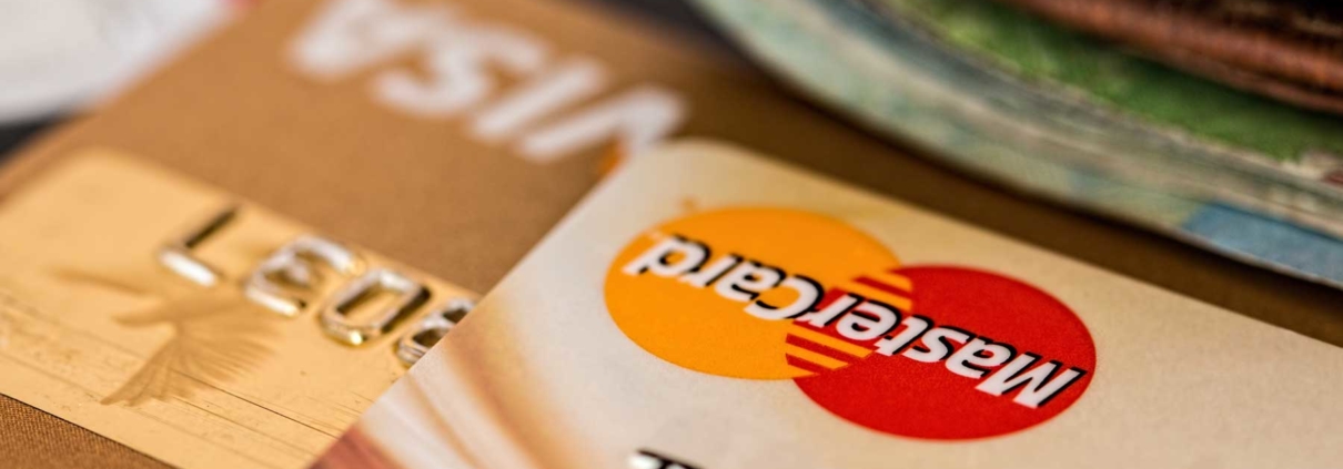 Close up of credit cards with a wallet in the foreground.