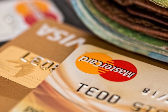 Close up of credit cards with a wallet in the foreground.