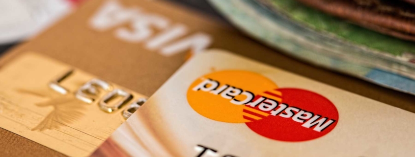 Close up of credit cards with a wallet in the foreground.