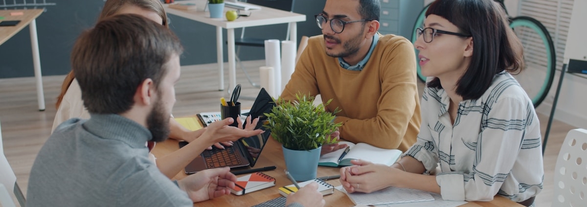 Creative agency team discussing work around a table
