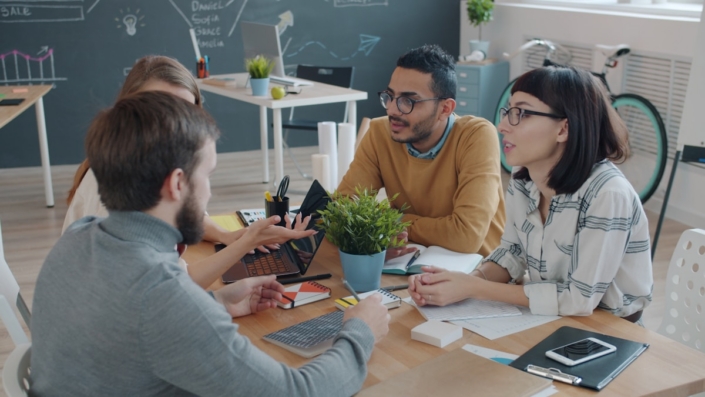 Creative agency team discussing work around a table
