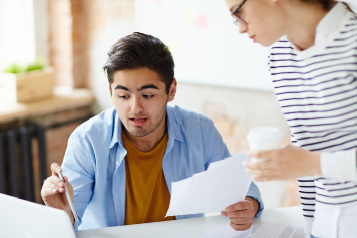 Two colleagues reviewing a financial document together