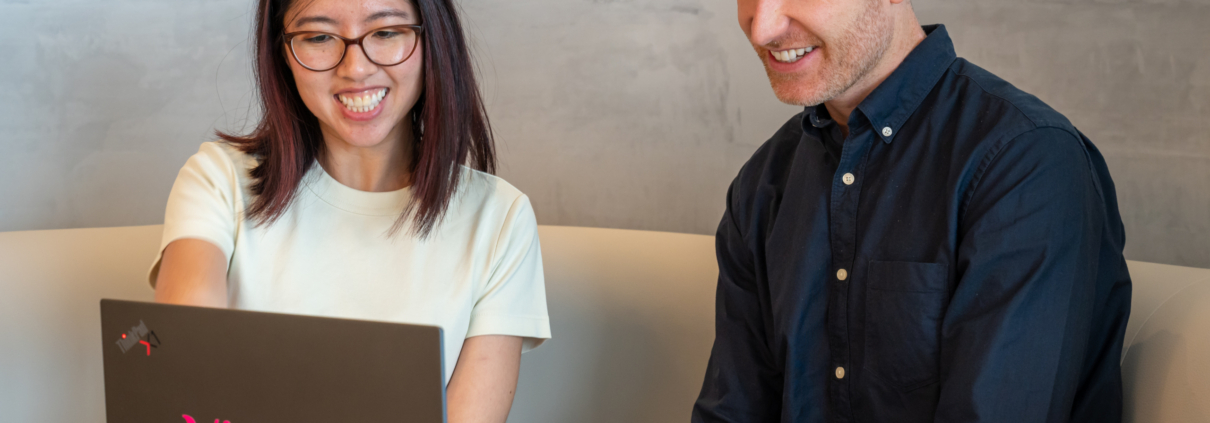 Two Visory team members reviewing work on a laptop